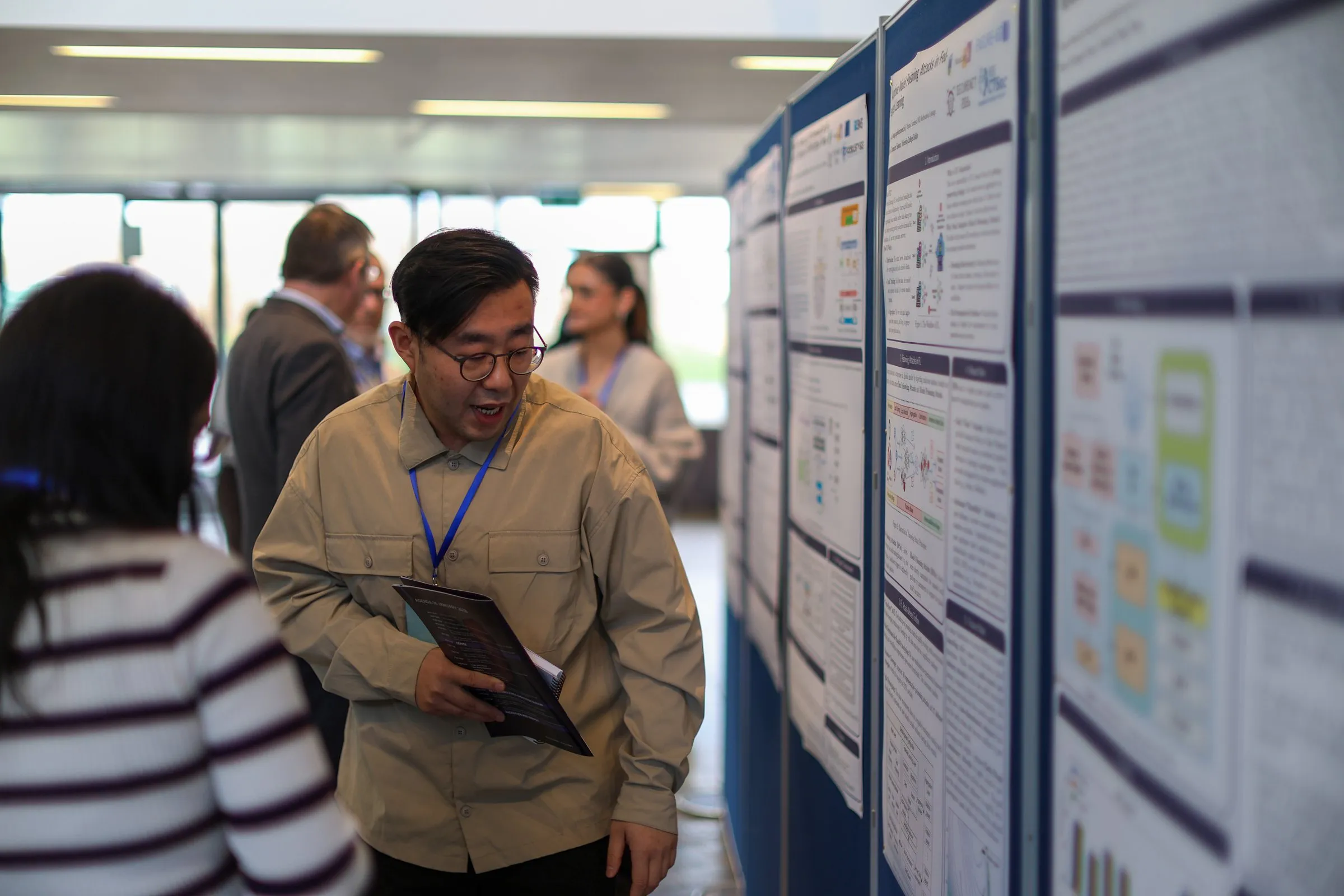 Attendees discussing research posters at SECURENET 2026